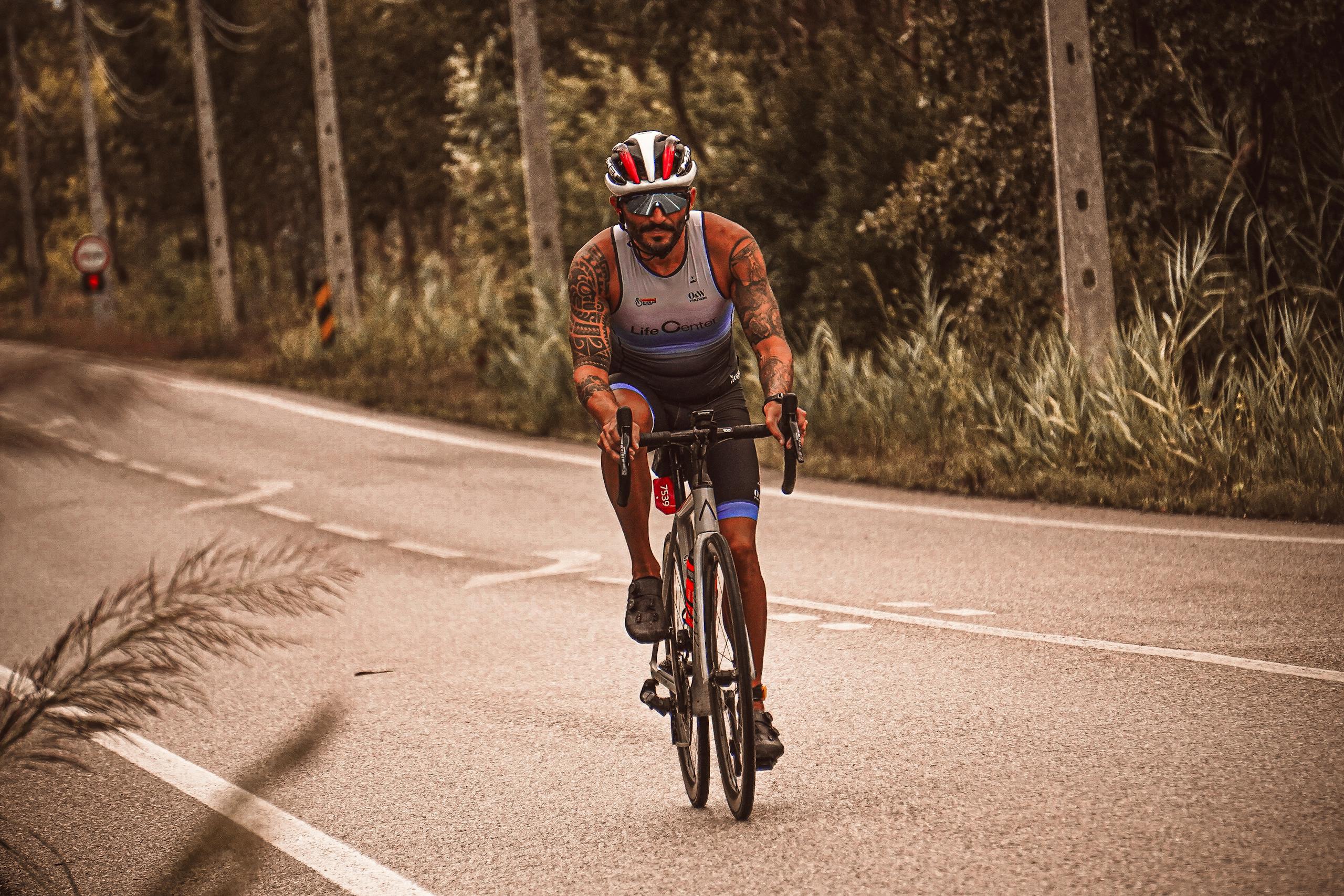 Athlete cycling on a winding road during a daytime outdoor workout.