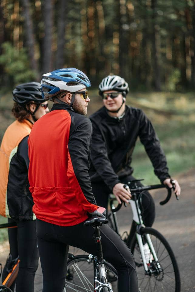 three cyclists stopped and chatting in the woods